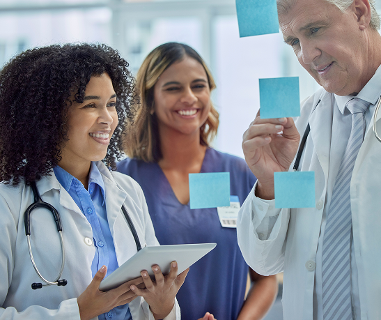planning-training-doctors-teamwork-glass-board-healthcare-management-internship-workflow-sticky-note-medical-students-people-woman-with-manager-writing-ideas-clinic-goals 1 (2)